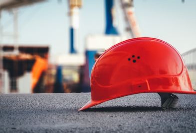 a red hard hat sitting on top of a cement ground.