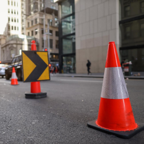 A street sign with traffic cones.