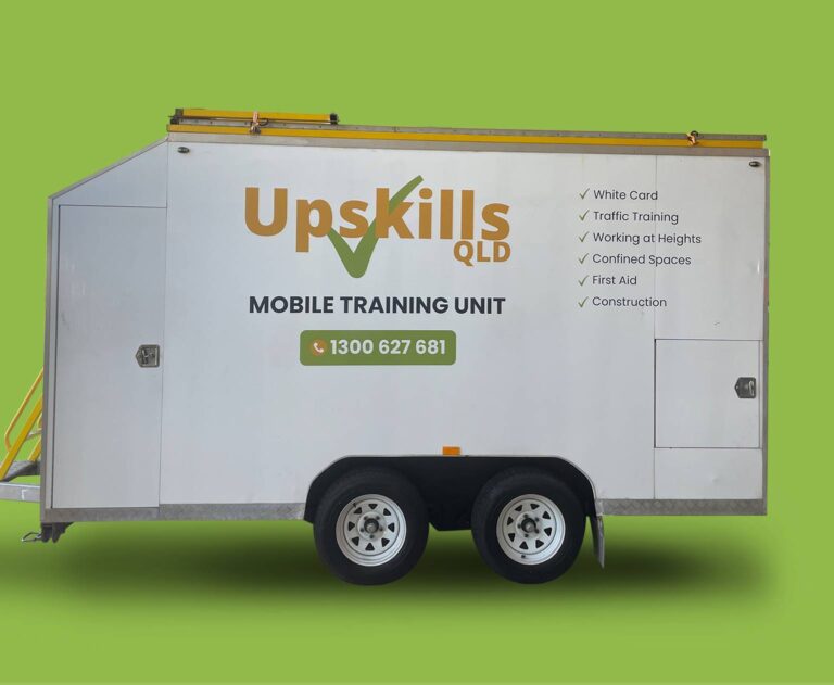 White mobile training unit trailer labeled "upskills qld" with contact information and listed services, parked against a green background.
