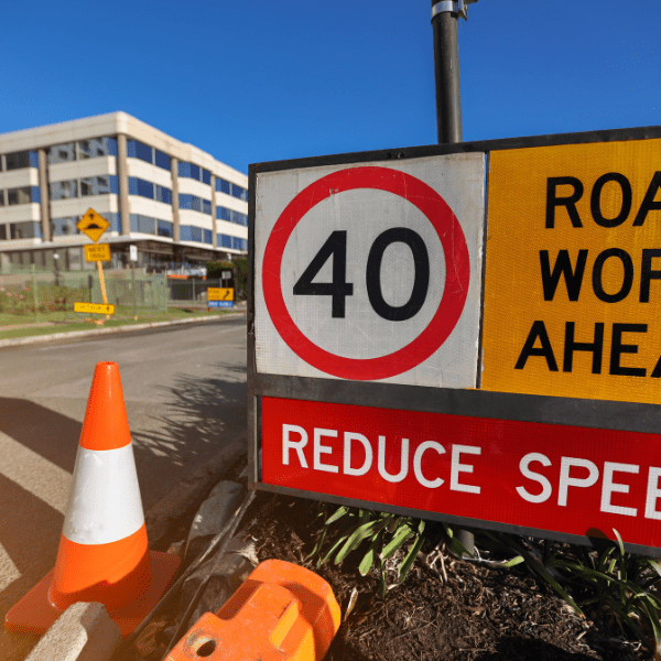 A construction cone and road work ahead sign in the traffic industry.