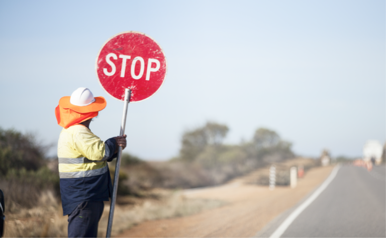 a man holding a stop sign on the side of the road.