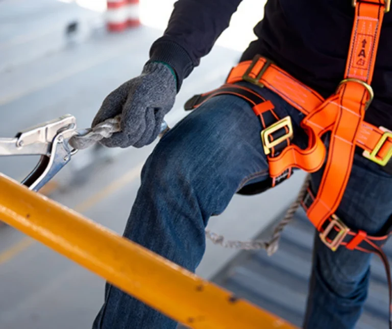 Close-up of harness and lanyard connection used for Work at heights safety compliance.