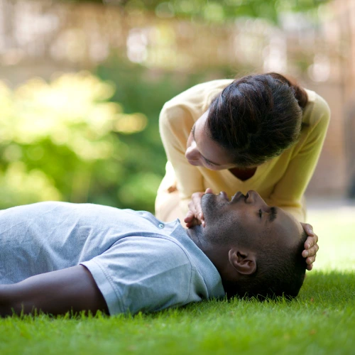 First aid training demonstrating airway check and patient positioning outdoors