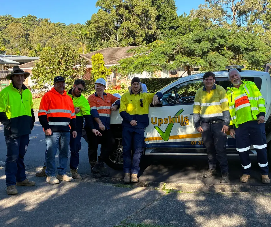 Traffic Management Implementation (TMI) training participants with an Upskills QLD trainer during practical traffic management training in Queensland, preparing for careers in roadwork and civil construction.